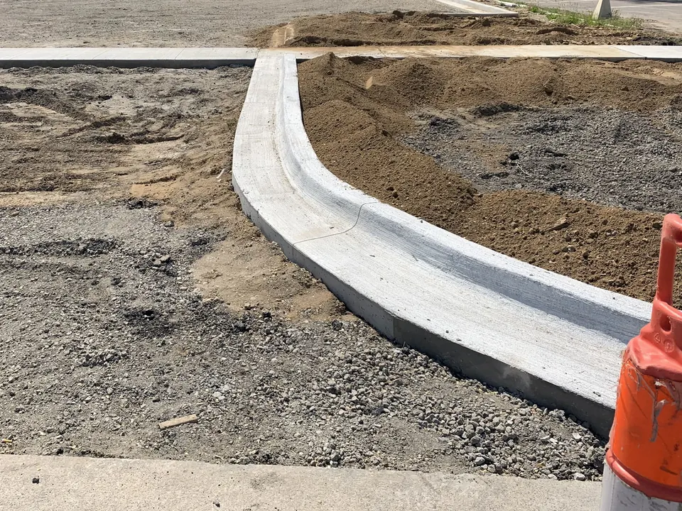 New curved concrete curb and a sidewalk edge on a commercial lot under construction, commercial concrete flatwork