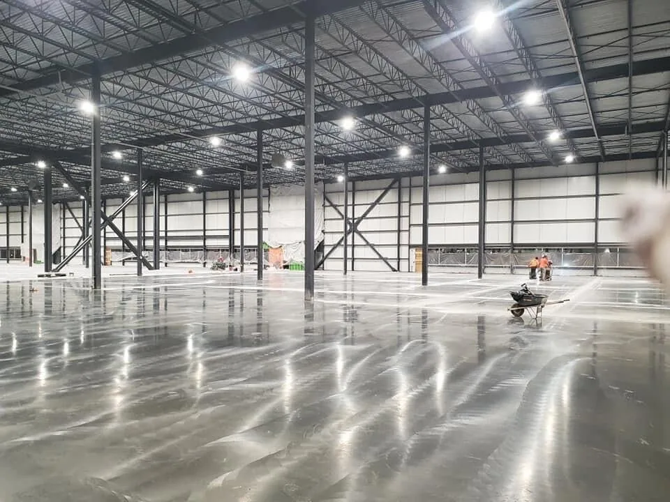 New concrete floor slab inside a steel warehouse building, commercial concrete