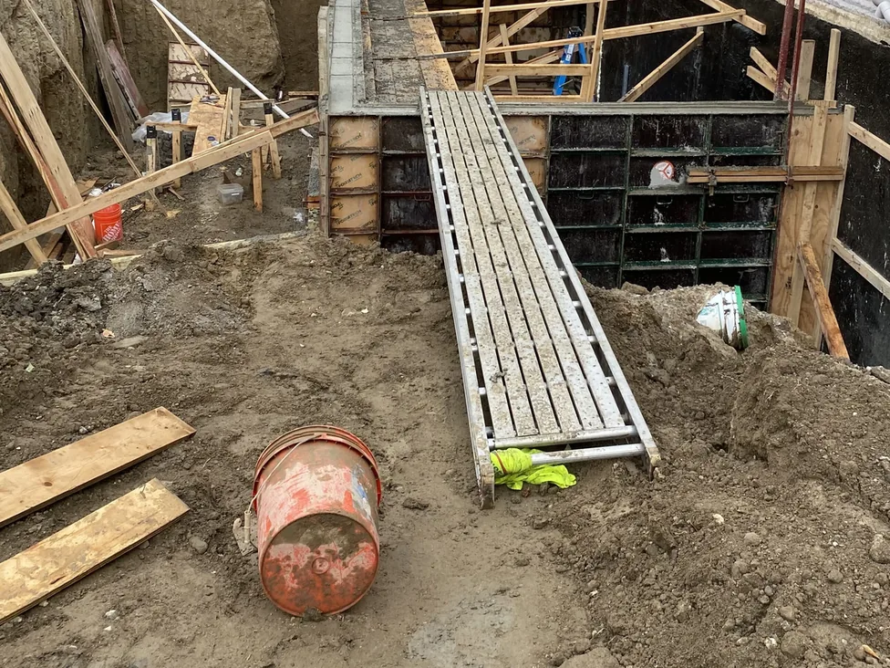 Foundation wall forms set beside a modern house, concrete foundations
