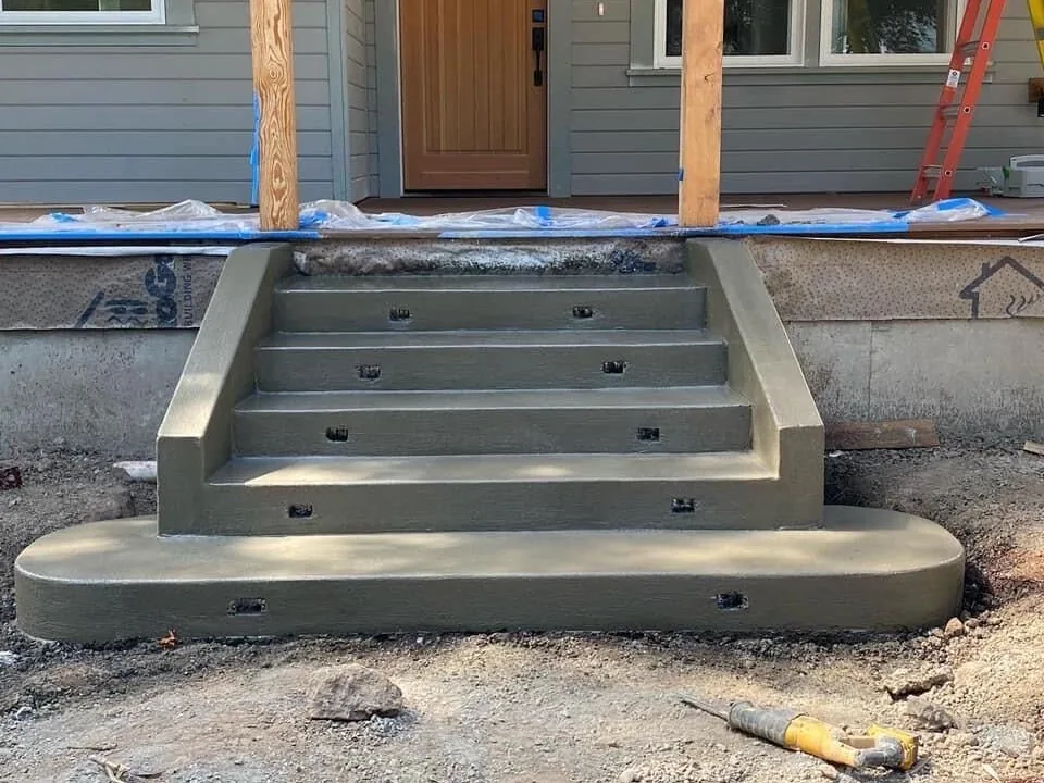 New concrete front steps with recessed step light openings at a front door, concrete steps