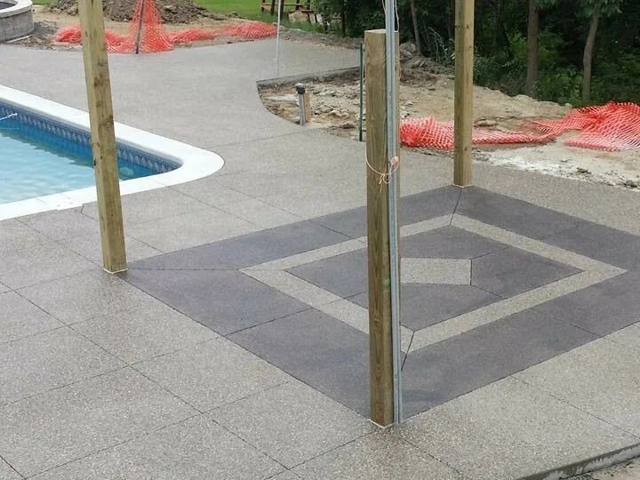 Inground pool corner with an exposed aggregate deck, a dark diamond inlay and new pergola posts, inground pools