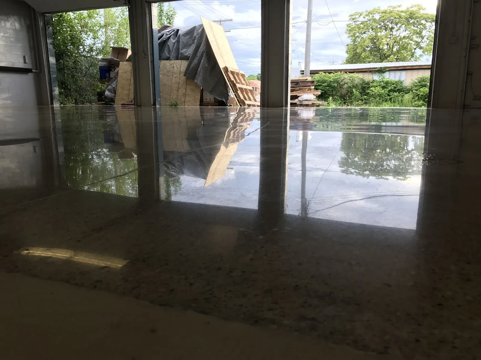 High gloss polished concrete floor reflecting an open dock door, polished concrete floors